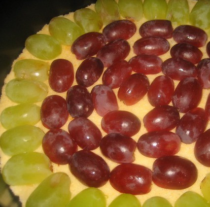 1. Этап. Торт с маскарпоне без выпечки: 3. Корж выкладываем на дно формы, обрезаем лишнее. Выкладываем половинки винограда, смазываем белым кремом.