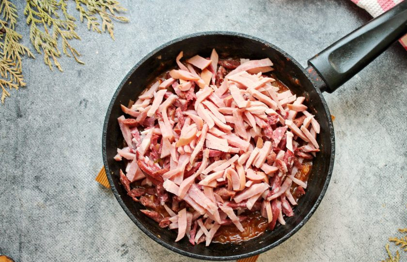 1. Этап. Солянка Московская: Сосиски, копченую колбасу очистите от оболочки и порежьте соломкой. Добавьте колбасы в сковороду с овощами и обжаривайте в течение 5-6 минут.