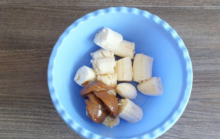 1. Этап. Мороженое из банана и сгущенки: Бананы очистите, поломайте на кусочки, выложите в чашу. Туда же добавьте варёное сгущенное молоко.