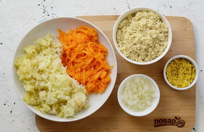 1. Этап. Вегетарианская Мимоза: Картофель и морковь натрите на крупной терке. Лук порубите на мелкие кубики, по желанию ошпарьте кипятком, чтобы ушла горечь. Тофу натрите на мелкой, добавьте черную соль и хорошо перемешайте. Отложите небольшую часть тофу для украшения салата, добавьте в нее куркуму. Перемешайте, чтобы она равномерно окрасилась в желтый цвет.