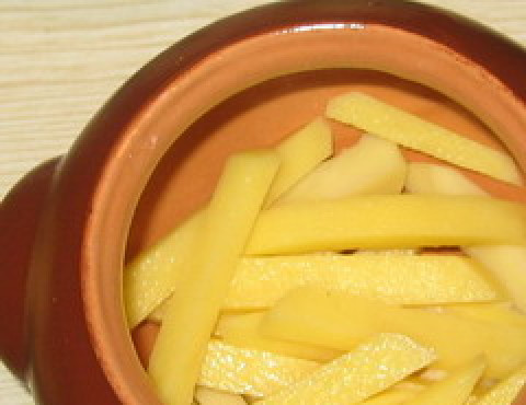 1. Этап. Жаркое из кролика в горшочках: Картошку порежьте соломкой, половину выложите на дно горшочков.