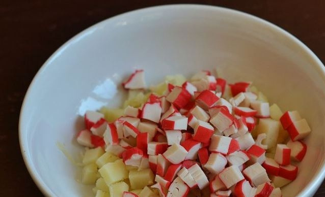 1. Этап. Салат с крабовыми палочками, яйцом и майонезом: Если вы используете замороженные крабовые палочки, то их следует предварительно разморозить. Нарежьте палочки кубиками такого же размера, как и картофель.