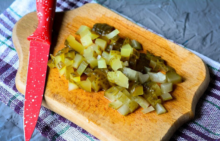 1. Этап. Салат из печени трески с горошком и огурцом: Соленые огурцы нарежьте кубиками.