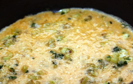 1. Этап. Фриттата: Выливаем сырно-яичную смесь на овощи, накрываем сковороду крышкой и тушим на среднем огне, пока не загустеет.