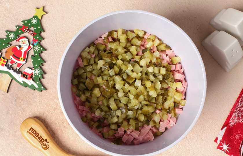 1. Этап. Салат Оливье на год Кролика: Огурцы нарежьте кубиками, слегка отожмите и добавьте к остальным ингредиентам.