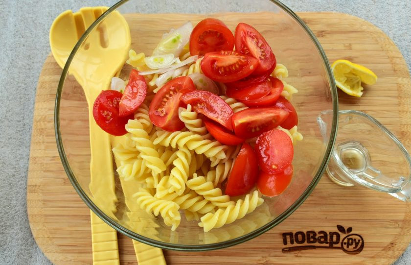 1. Этап. Паста-салат с консервированным тунцом: Помидоры черри нарежьте на половинки или четвертинки, лук — тонкими полукольцами. В глубокой миске соедините фузилли, помидоры, лук. Соедините лимонный сок, растительное масло, заправьте салат. Посолите и поперчите по вкусу. Дайте постоять в течение 5 минут.