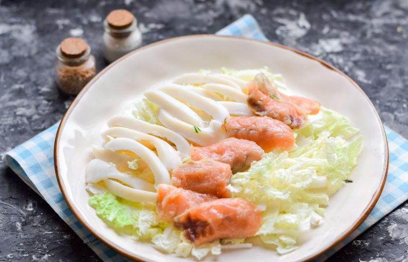 1. Этап. Салат из пекинской капусты с морепродуктами: Рядом с кальмаром разложите нарезанные кусочки красной рыбы.