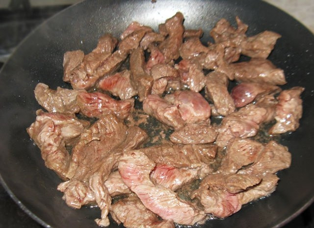 1. Этап. Говядина с макаронами: Говядину порежьте тонкими брусочками или ломтиками. Обжарьте на той же сковороде до румяного цвета, потом налейте воду, чтобы мясо было покрыто наполовину, убавьте огонь и тушите примерно час до готовности (говядина тушится долго, время от времени можете подливать воду).