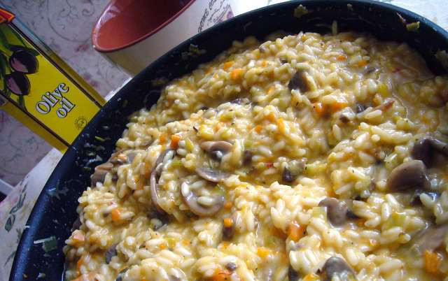 1. Этап. Ризотто с овощами и грибами: Добавьте масло и сыр в ризотто, интенсивно все перемешайте.