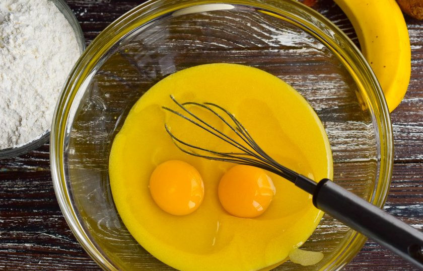 1. Этап. Медовик с бананом и киви: Когда масса немного остынет, вбейте яйца. Перемешайте.