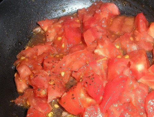 1. Этап. Быстрая пицца из батона: Помидоры вымойте и обдайте кипятком, чтобы было легко снять с них кожицу. Затем нарежьте их как можно мельче. Можете даже натереть их на терке. Переложите томаты в сковородку, добавьте соль и специи, тушите на небольшом огне до полного испарения жидкости. Это будет ваш соус для пиццы.