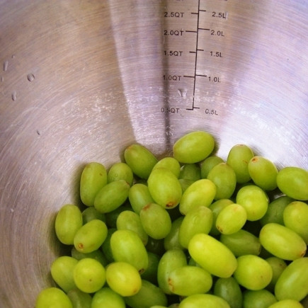 1. Этап. Фруктовый салат с медовым сиропом: Кладем в салатную миску виноград (целиком).