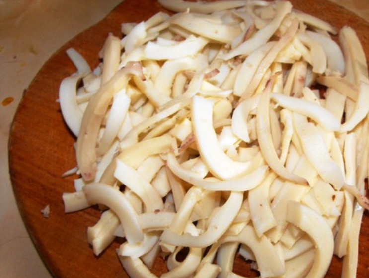 1. Этап. Салат из кальмаров с овощами: Кальмары очистите и бросьте в кипящую соленую воду на 10 секунд. Затем нарежьте соломкой.