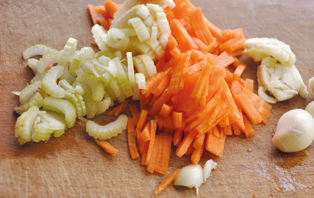 1. Этап. Голубцы из молодой капусты: 8. Шинкуем лук, лук порей, морковь и чеснок, обжариваем все до готовности. В самом конце добавляем томатную пасту, заливаем водой. Тушим около двух минут, после чего заливаем полученным соусом голубцы.