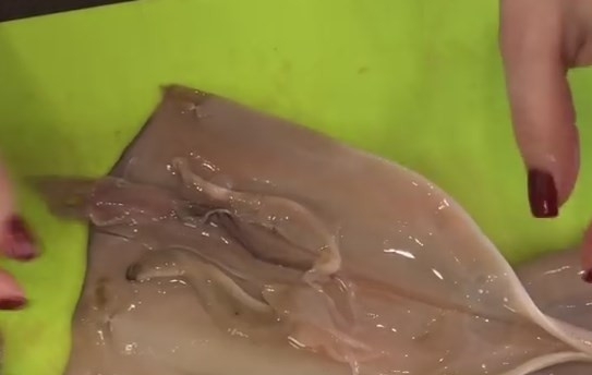 1. Этап. Салат из кальмаров с морковью по-корейски: 2. Сделайте надрез на тушке, удалите твердую часть и очистите слизь и пленку под проточной водой. Щупальца отрежьте.