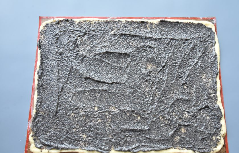 1. Этап. Краффин с маком: Распределите по тесту половину подготовленной маковой начинки. Аккуратно скатайте тесто с начинкой по длинной стороне в плотный рулет.