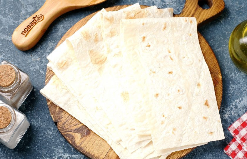 1. Этап. Конвертики из лаваша с варёными яйцами и сметаной: Лаваш нарежьте кухонными ножницами на длинные полоски, шириной около 7-10 см.