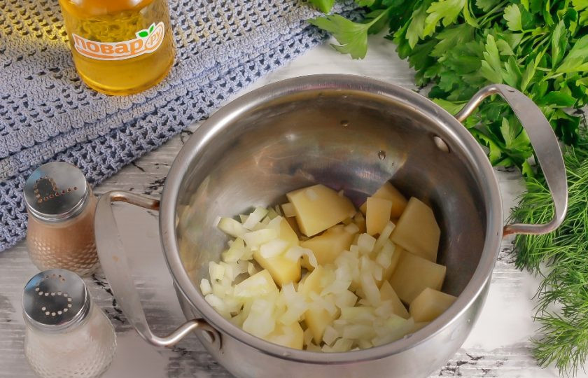 1. Этап. Рыбный суп с икрой мойвы: Очищенный картофель нарежьте средними кубиками, а лук мелкими кубиками. Добавьте овощные нарезки в кастрюлю или казан.