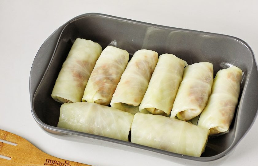 1. Этап. Голубцы по-румынски: Готовые голубцы переложите в смазанную маслом форму для запекания.