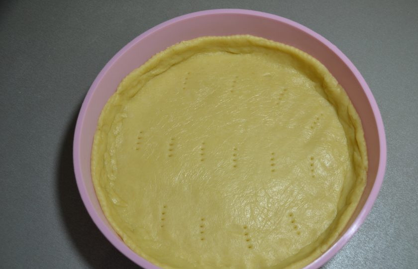 1. Этап. Пирог с зеленым луком и творогом: Выложите тесто в форму, предварительно раскатав в пласт и перенеся в форму, оформите бортики, наколите вилкой дно и выпекайте 5 минут при температуре 200 градусов.