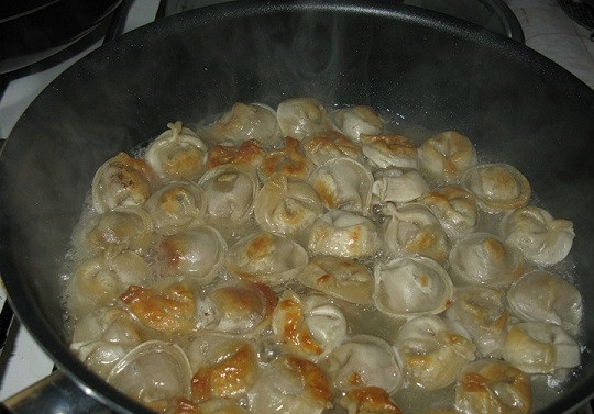 1. Этап. Жареные пельмени: 4. Чтобы замороженные пельмешки хорошо проготовились, влейте на сковороду горячую воду (так, чтобы она покрыла их). Оставьте на среднем огне до тех пор, пока вода полностью не выкипит. Перед подачей можно дополнить маслом, щепоткой перца, зеленью или сметаной. Приятного аппетита!