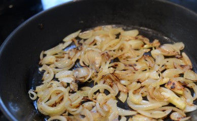 1. Этап. Печень с луком и яблоками: Обжаренные яблоки выкладываем на тарелочку и в том же масле обжариваем лук нарезанный полукольцами. Обжариваем его, постоянно перемешивая, до золотистости.