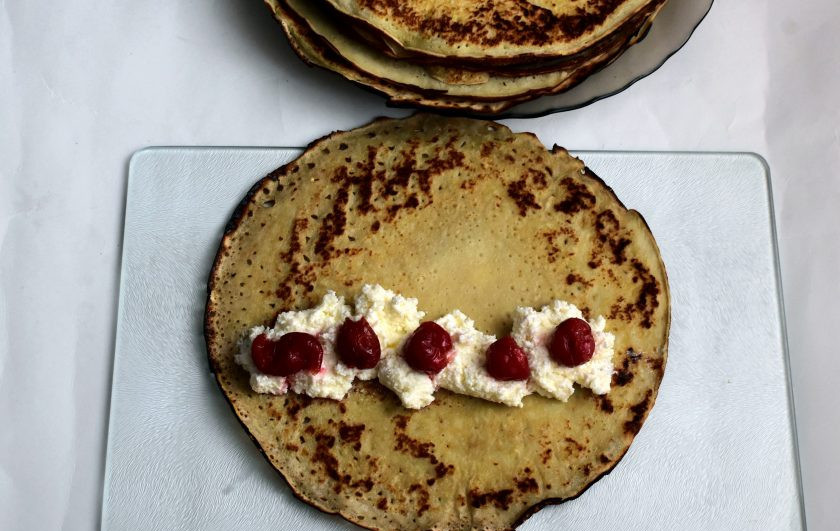 1. Этап. Блинный торт с шоколадной заливкой: Выкладывайте начинку на блинчик дорожкой, сверху выложите по несколько штук вишен.