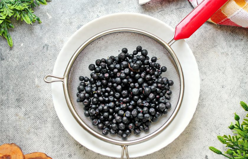 1. Этап. Настойка из черники с крыжовником на самогоне: Чернику сполосните, откиньте на сито и дайте воде полностью стечь.