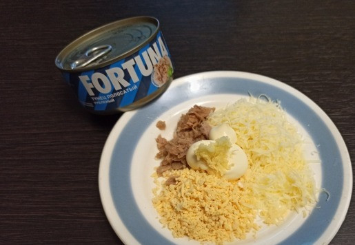 1. Этап. Фаршированные яйца Глаз дракона: Яйца сварить вкрутую и аккуратно разрезать пополам. Желток натереть на терке. Сыр натереть на терке. Консервированного тунца FORTUNA размять вилкой. Добавить майонез и маленький зубчик чеснока.