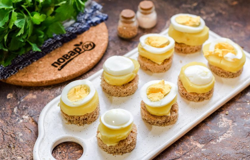 1. Этап. Канапе с килькой и яйцом: Отварите вкрутую яйцо, нарежьте его кружочками и выложите поверх картофеля.