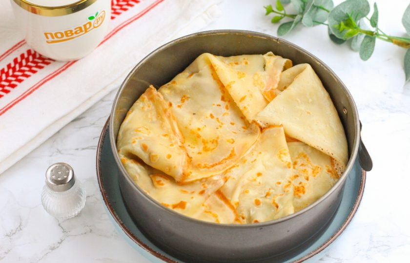 1. Этап. Блинный пирог с творогом: Когда выложите оставшуюся начинку, заверните свисающие края блинов внутрь формы. Они должны закрыть начинку. Разогрейте духовку и накройте верх пирога пергаментной бумагой, чтобы блины не подгорели, пока начинка приготовится.