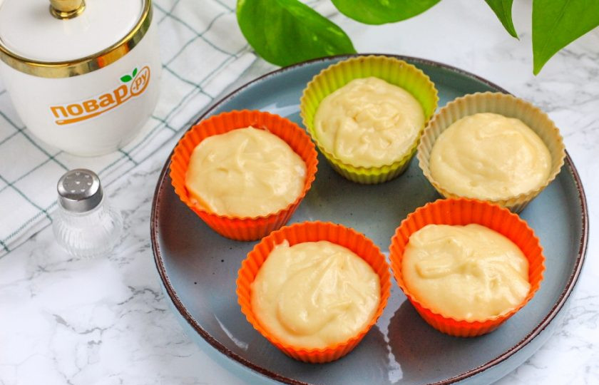 1. Этап. Ванильные капкейки: Разогрейте духовку до 180 градусов. Выложите по 1,5 ст.л. теста в формочки для капкейков и поместите их в духовку на 15 минут. Формочки должны быть заполнены на две трети от объема. По желанию можно сначала выложить в них бумажные формочки, а затем — тесто.