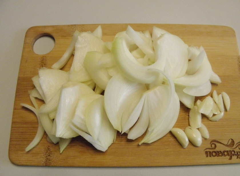1. Этап. Пикантные огурчики на зиму: Очищенный лук и чеснок порежьте не слишком тонко, например — полукольцами и дольками соответственно.