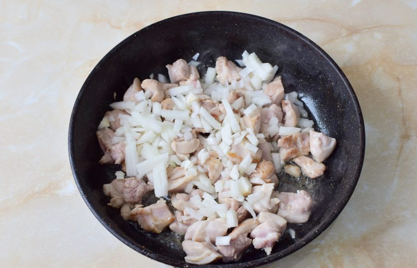 1. Этап. Фрикасе из курицы классическое: Добавьте лук в сковороду к курице. Перемешайте. Обжарьте в течение минуты. От лука появится характерный аромат. Затем закройте крышкой и сделайте минимальный огонь.