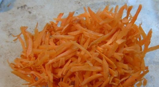 1. Этап. Кресс-салат: Морковь вымойте, очистите от кожуры и натрите на терке. Выложите подготовленный корнеплод в креманку или стеклянную миску.