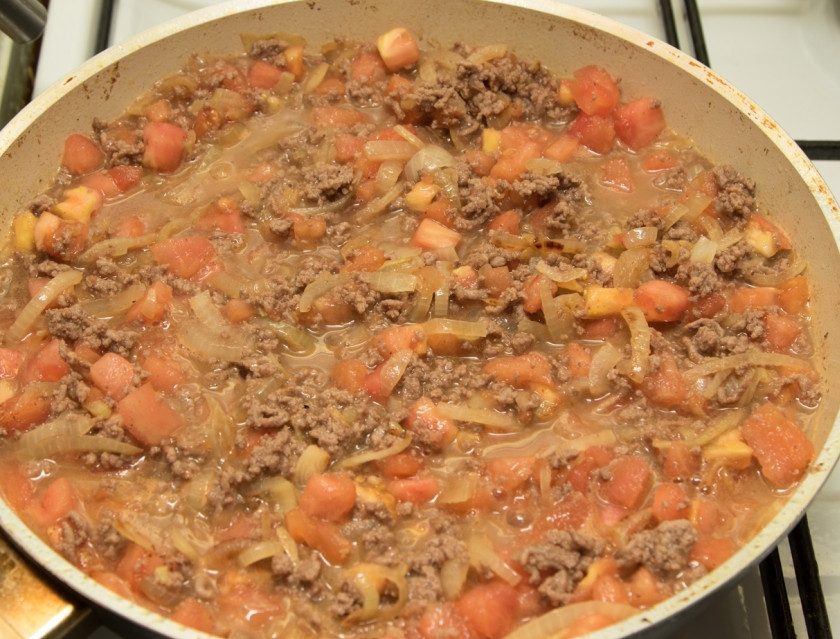 1. Этап. Мусака классическая: Добавьте к фаршу лук, помидоры, вино, соль, перец, корицу и тушите до полного выпаривания жидкости.