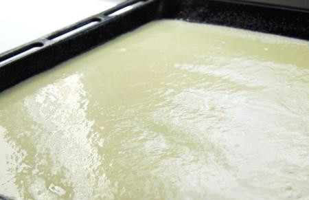 1. Этап. Пирог со щавелем на тонком тесте: Противень надо смазать растительным маслом и слегка посыпать манкой. Выливаем на него тесто.