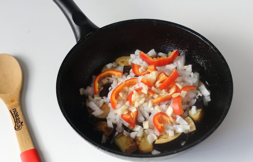 1. Этап. Гречка по-бакински: Жарьте баклажаны около 7 минут или до мягкости. После чего добавьте нарезанный кубиками лук и соломкой болгарский перец.