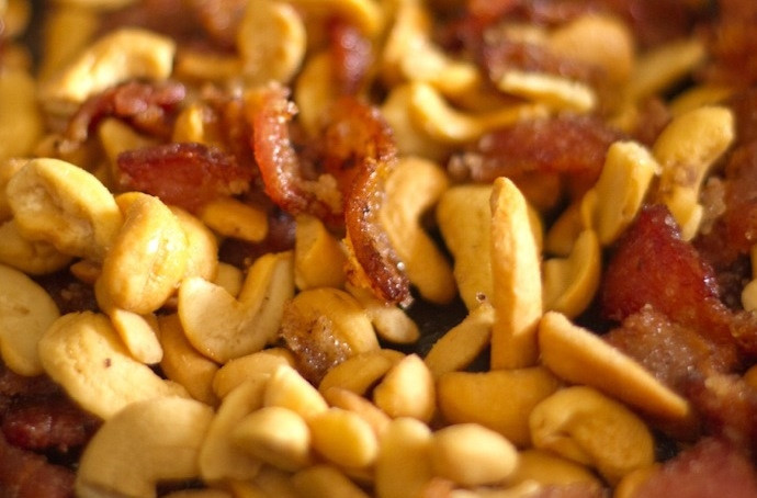 1. Этап. Глазированные кешью с беконом: 2. Добавьте кешью, карри, соль и перец. Перемешайте все ингредиенты в сковороде.