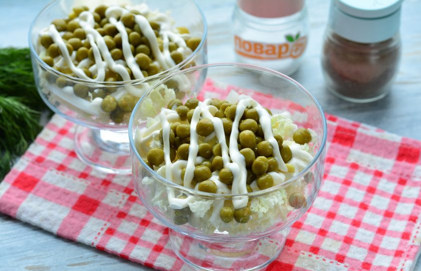 1. Этап. Слоеный салат из пекинской капусты: Вторым слоем распределите консервированный горошек, полейте соусом.