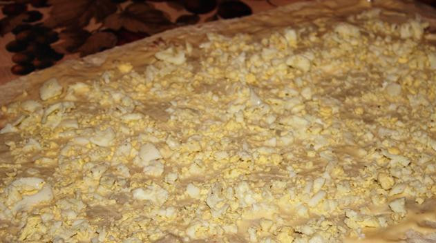 1. Этап. Рулет из лаваша с сайрой: Накрываем этот слой вторым листом лаваша и так же обмазываем его сыром, сверху посыпаем измельченными яйцами.