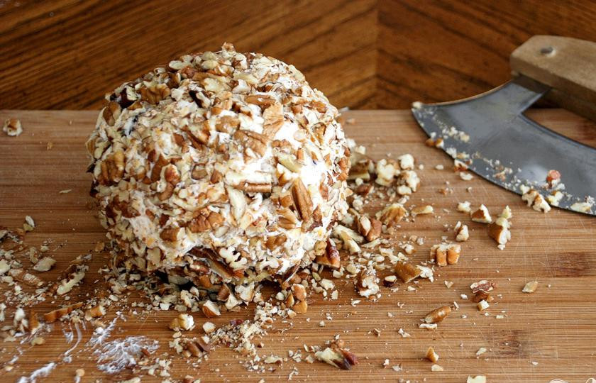 1. Этап. Сырный шарик: 4. Извлечь сырный шар из холодильника, убрать полиэтиленовой пленкой и посыпать по всей поверхности нарезанными орехами пекан.