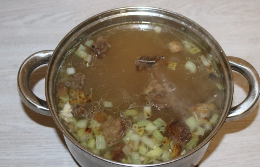 1. Этап. Борщ с карасями: Поставьте кастрюлю с водой на огонь, доведите до кипения, добавьте лавровый лист, перец, обжаренные грибы с луком и нарезанный картофель.