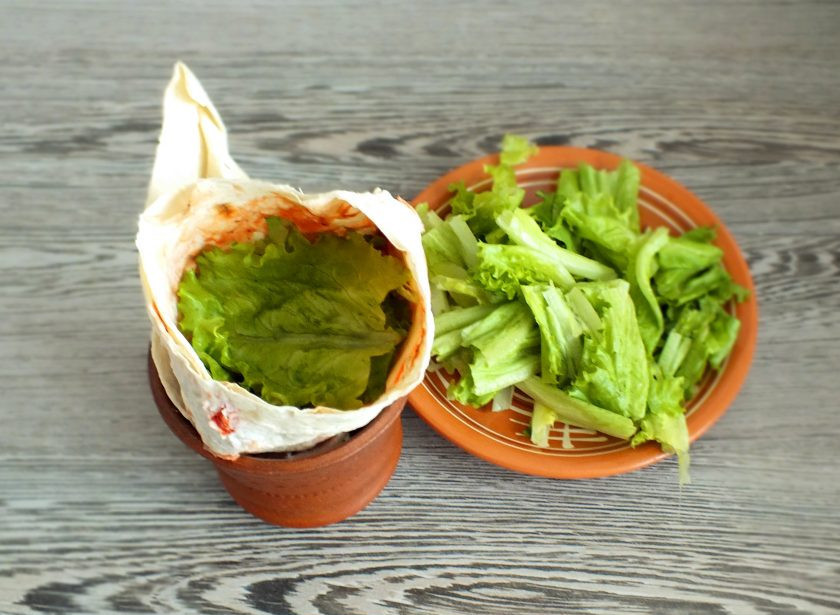 1. Этап. Бургер в лаваше: Для удобства наполнения лаваша, перенесите его в бокал. Салатный лист порвите руками на мелкие кусочки. Наполните лаваш салатным листом. Количество определяйте по вкусу.