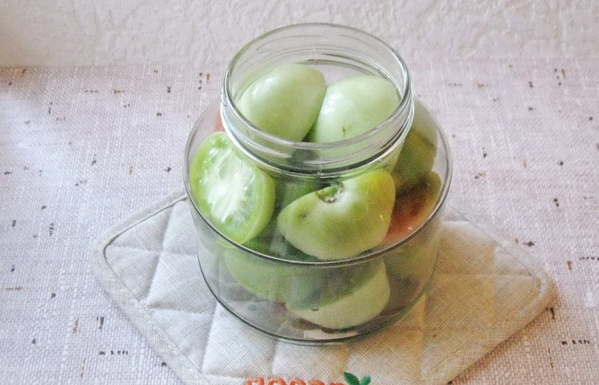 1. Этап. Зеленые помидоры на зиму без уксуса: Помидоры вымойте. Крупные разрежьте на половинки. Выложите в банку.