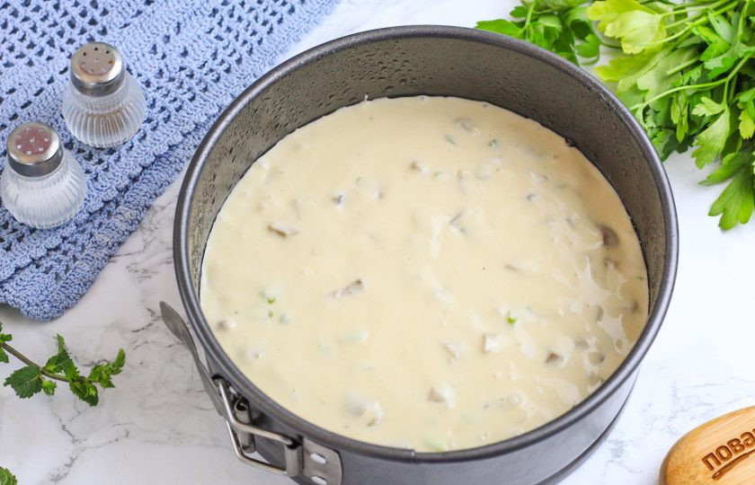 1. Этап. Пирог с солеными грибами: Разогрейте духовку до 180 градусов и смажьте форму растительным маслом, заходя и на бортики. Выложите в нее приготовленное тесто и отправьте в духовку.