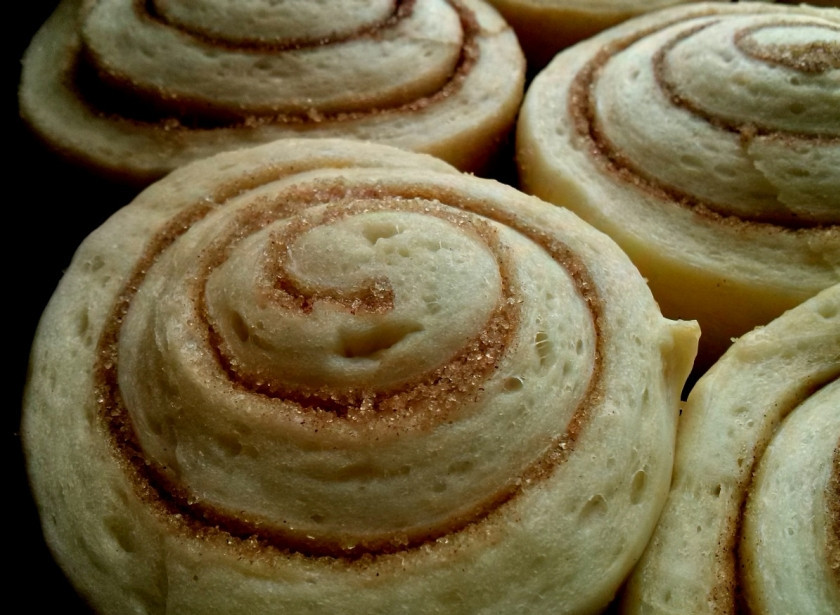 1. Этап. Булочки с корицей Синнабон: Острым тонким ножом разрежьте рулет на 12 частей (по 2,5 см. каждая). Получившиеся роллы выложите на противень, выстланный силиконовым ковриком (или пергаментом) на расстоянии 3 см. друг от друга. Накройте форму пищевой пленкой (полотенцем) и оставьте для подъема на один час. Вот булочки поднялись и слегка соприкоснулись друг с другом.