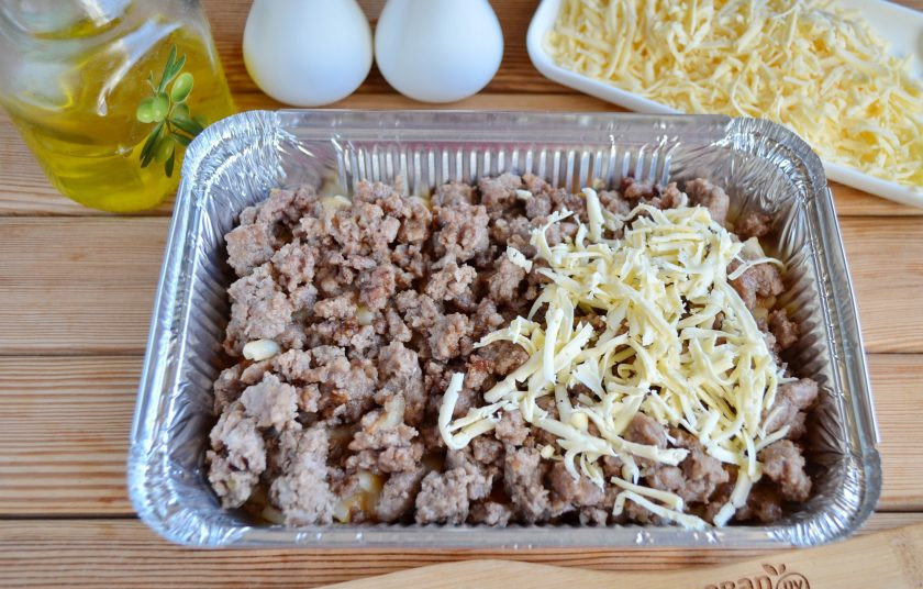 1. Этап. Паста Аль форно: Далее распределите жареный лук с фаршем. Половину сыра тертого. Можно добавить еще кубики другого сорта сыра.