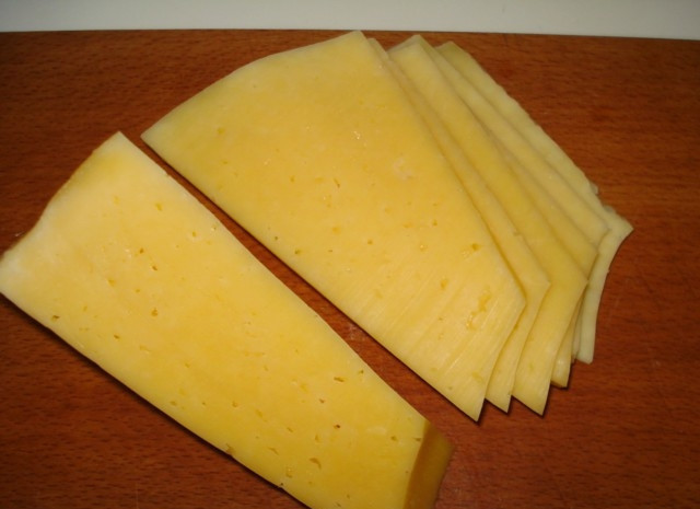 1. Этап. Лазанья сырная: Нарежьте сыр тонкими слайсами. Он у нас будет играть роль пасты лазаньи. Небольшую часть натрите для финального слоя.