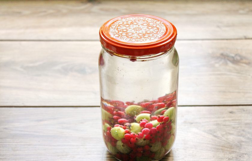 1. Этап. Компот из крыжовника и красной смородины на зиму: Воду доведите до кипения и залейте банку с ягодами до самого верха, прикройте крышкой и дайте постоять 15 минут.